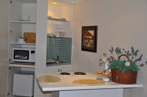 Cottage kitchen/dining with and wash up area. Microwave fridge pots glasses etc