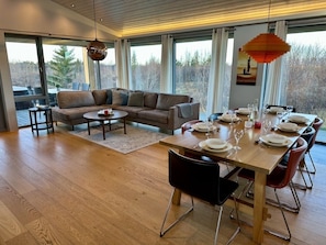 Beautifully furnished open living room/kitchen with floor to ceiling windows.