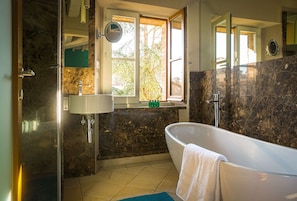 The ensuite bathroom has a glamorous bath tub and views of neighbouring gardens