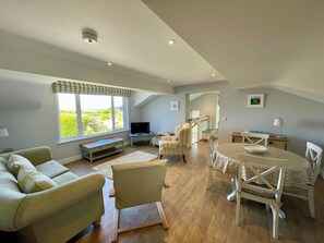 Large open plan room with beautiful sea and sunset views and a big comfy sofa .