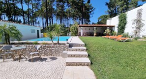 Baksidan av huset med privat trädgård och pool.