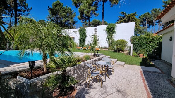 Baksidan av huset med privat trädgård och pool.