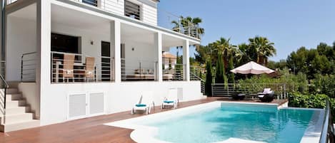 view of villa and pool looking up from deck area