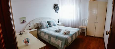 Quarto twin bem iluminado com cama de casal, mesinhas de cabeceira, cómoda.