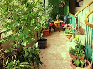 Green terrace with chairs and table in front of the apartment.