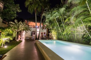 Fantastic night time experience by the pool with outdoor dining area.