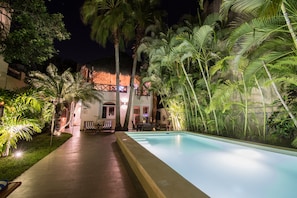 Fantastic night time experience by the pool with outdoor dining area.