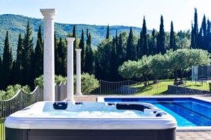 Hot tub and pool area surrounded with beautiful views of nature