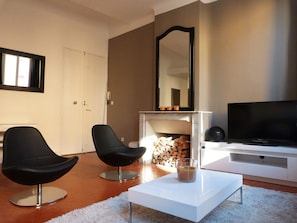 salon, vue du canapé sur TV et cheminée