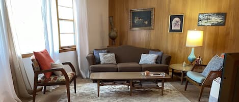 Mid century living room with flatscreen smart TV and plenty of natural light