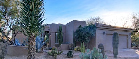 Front Entrance of the property with two-car garage, offers desert landscaping