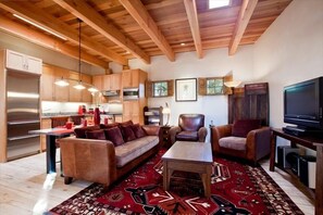 Living area with hand-woven rug on hardwood floors and cozy sitting areas.