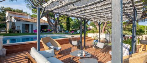 Vue générale de la terrasse, de la piscine et de la maison.