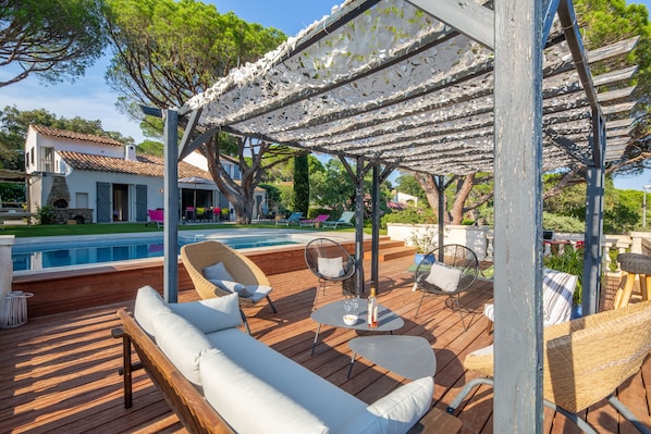 Vue générale de la terrasse, de la piscine et de la maison.
