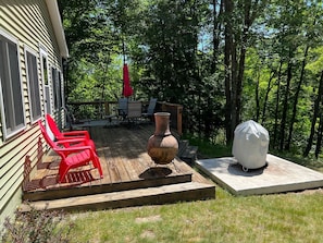 Deck overlooking the river with charcoal grill and chiminea.