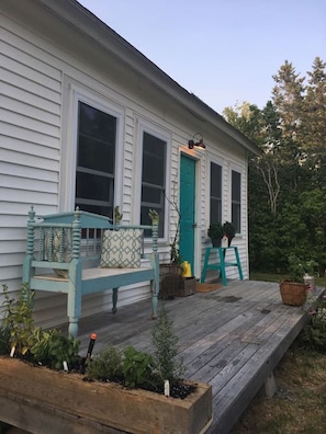 Crabapple cottage exterior entrance...culinary herbs, a bench...