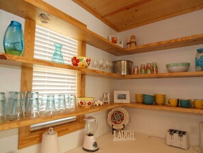 Coffee maker, toaster, blender and shrimp pot. Plenty of plates, cups, & bowls. 