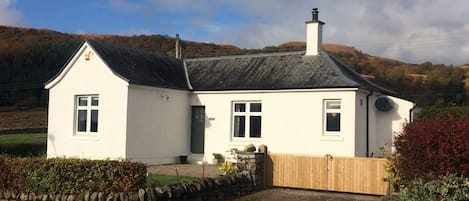 Front of house enclosed garden by wooden gates