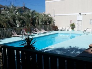 Private pool with lounge chairs and picnic tables.