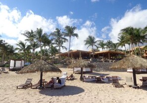 The Peninsula Restaurant in the background, under the roof, right on the beach