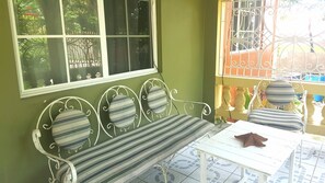 

Spacious front porch looking into the garden. Guest favorite to eat and relax.