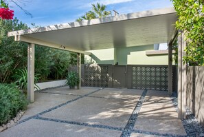 Driveway with lighted carport.  Parking for three cars, two covered.