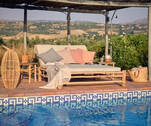 Relax on the reclining double bed under the pergola with views to the mountains.