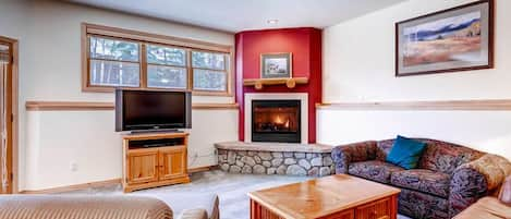 Spacious living room with gas fireplace, flat screen, and fold out couch.