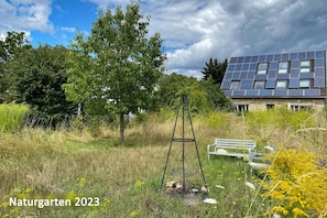 Feuerstelle im Naturgarten: Wiesen statt Rasen für mehr Biodiversität.