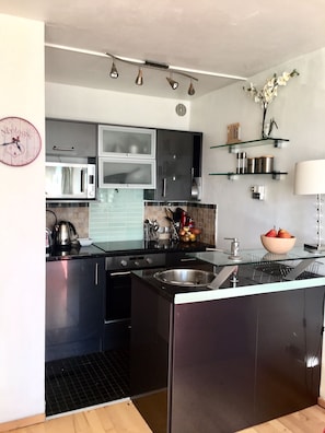 Kitchenette with modern utilities - cooker, electric hob, microwave & dishwasher