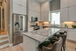 Kitchen is fully stocked with dishes, pots and pans, glassware, and utensils.