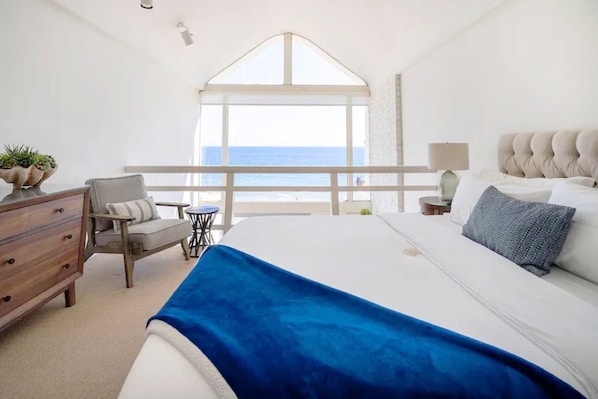 Primary bedroom has an oceanfront view, vaulted ceiling and en-suite bathroom