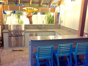 Outdoor kitchen with gas grill, sink and refrigerator