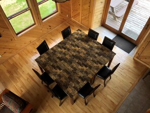 Dining area connects to kitchen and living room, opens onto deck with grill.