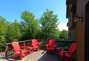 Deck with sitting area, picnic table, and gas grill.