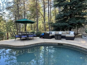 Comfy couch with ottoman and propane fire pit. Seating for 8 to dine next to it.