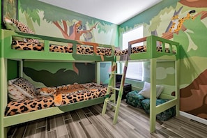 Jungle Cruise themed room has custom bunk beds, fun mural and reading "cave" under  the bed.