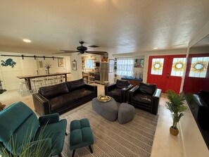 Great room with leather sectionals, brand new 70 in smart TV,  movable ottomans.