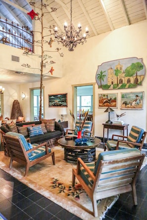 Living room with huge fireplace and TV, opens up to sunroom with more seating