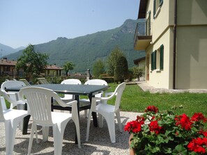 Terrasse im Garten, im Hintergrund der BBQ- Grill