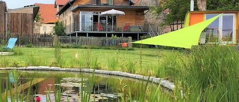 Gartenansicht mit Schwimmteich und finnischer Sauna