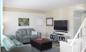 Living room with pull out couch (Queen Bed) and ottoman (twin bed).