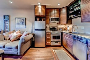 Fully equipped kitchen with stainless steel appliances including dishwasher, oven and range