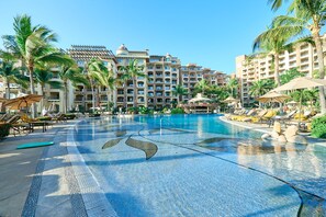 A huge, zero entry pool with waterfall, swim up bar, and tons of seating