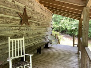 Porch wraps around the cabin & overlooks the pond, a small creek & springhouse.