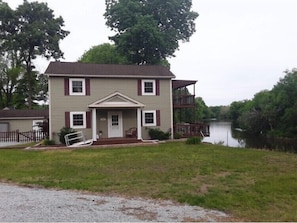 Road view of house with river in background. 