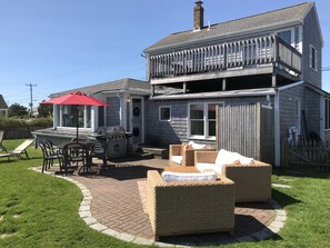 Backyard boasts an outdoor shower, lounging area, gas grill, and outdoor dining
