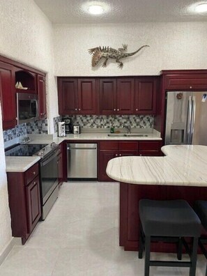 Remodeled kitchen with beautiful marble countertops and island.