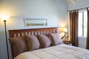 Master beach-themed bedroom with vaulted ceiling, tv, King Bed, & master bath