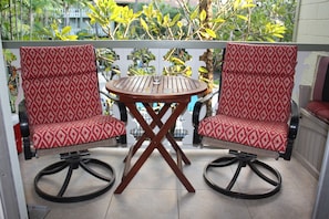 Swivel rockers dappled by sun shining thru the foliage of south-facing lanai